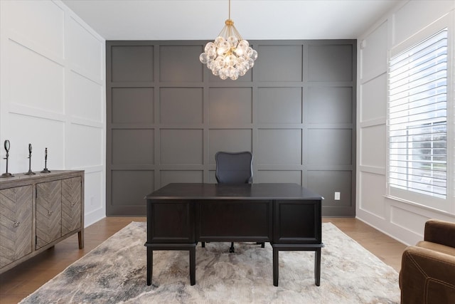 office space featuring light wood-type flooring and a chandelier