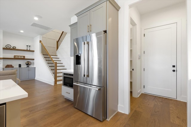 kitchen featuring hardwood / wood-style flooring, high quality fridge, and gray cabinets