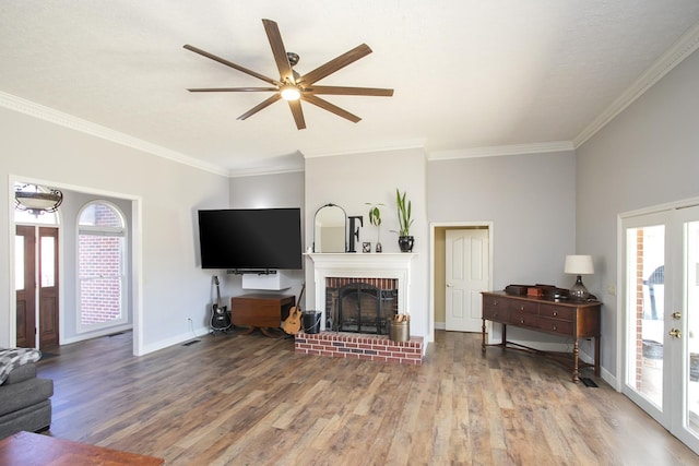 living room featuring hardwood / wood-style flooring, a wealth of natural light, a fireplace, and french doors