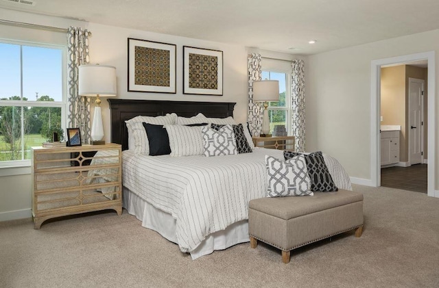 carpeted bedroom featuring ensuite bath