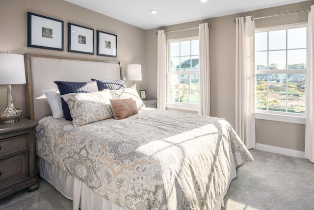 bedroom with light carpet and multiple windows