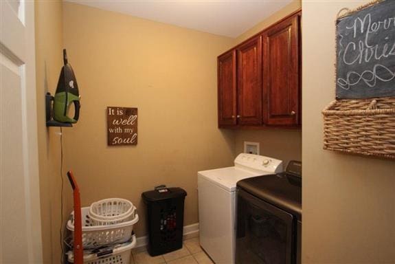 laundry room with independent washer and dryer, cabinets, and light tile patterned floors