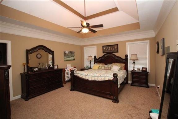 bedroom featuring a raised ceiling, crown molding, light colored carpet, and ceiling fan