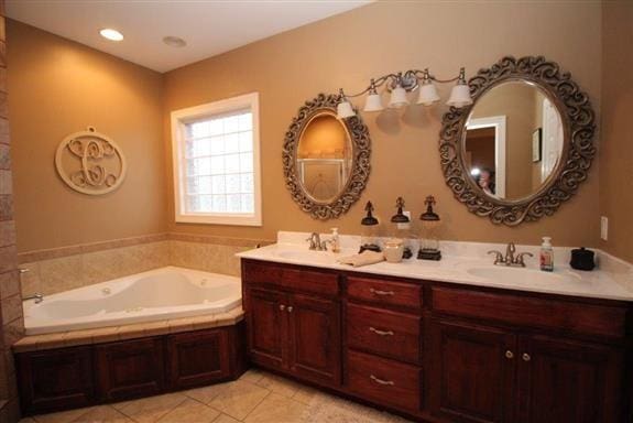 bathroom with vanity, a bathtub, and tile patterned flooring