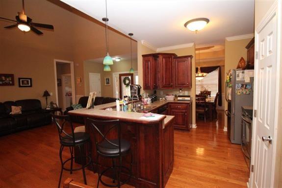 kitchen with hanging light fixtures, a breakfast bar, light wood-type flooring, and kitchen peninsula