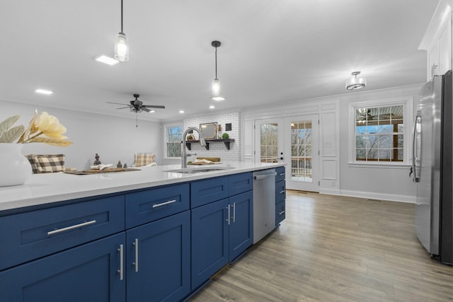 kitchen with blue cabinetry, french doors, sink, decorative light fixtures, and stainless steel appliances