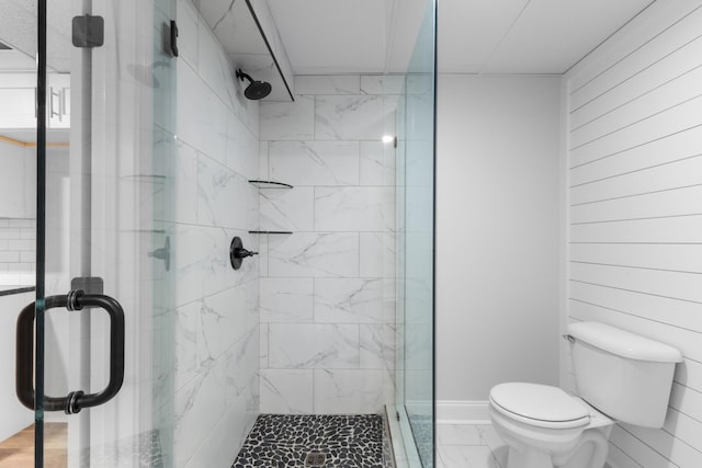 bathroom with a shower with shower door and toilet