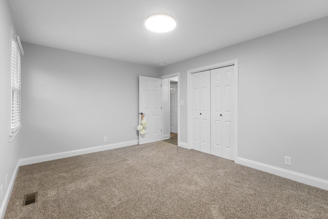 unfurnished bedroom featuring carpet and a closet