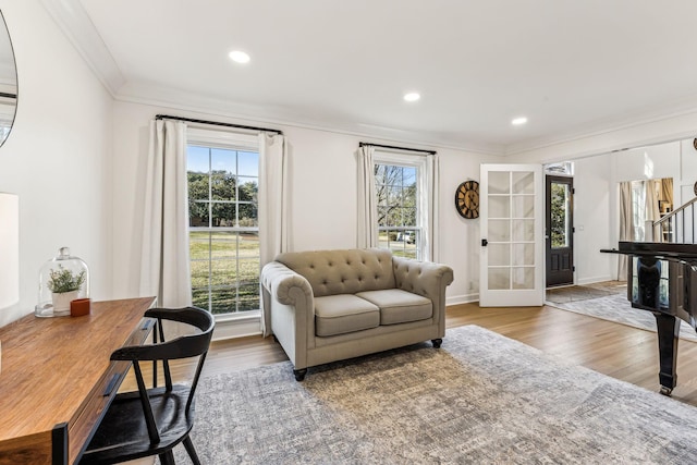 living room with wood-type flooring, ornamental molding, and french doors