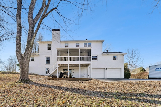 back of property with a garage, a sunroom, and ceiling fan