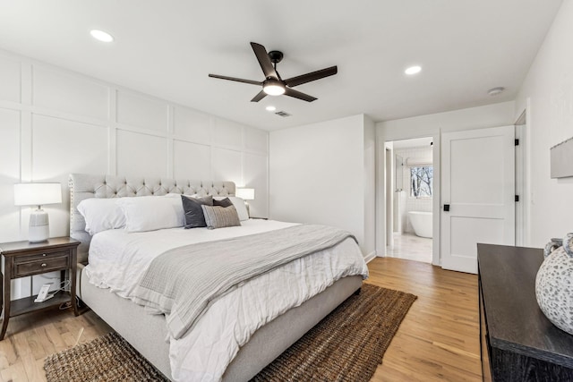 bedroom with light hardwood / wood-style flooring, ceiling fan, and ensuite bathroom