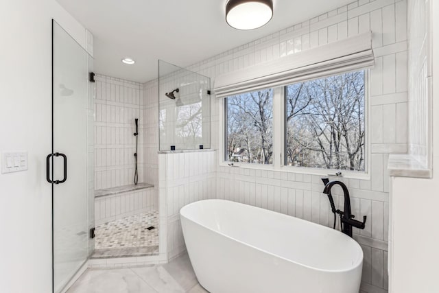 bathroom featuring tile walls and independent shower and bath