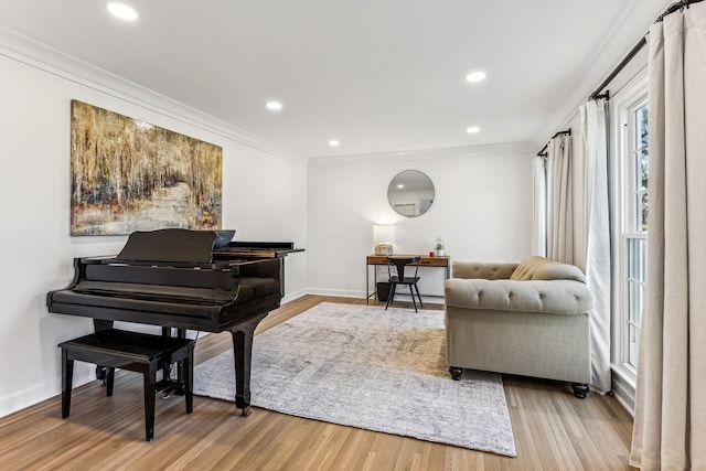 living area with ornamental molding and light hardwood / wood-style flooring