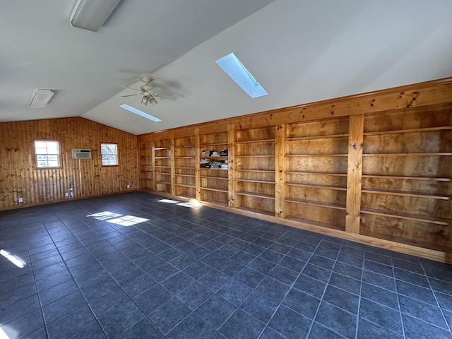 additional living space with ceiling fan, vaulted ceiling with skylight, built in shelves, an AC wall unit, and wood walls