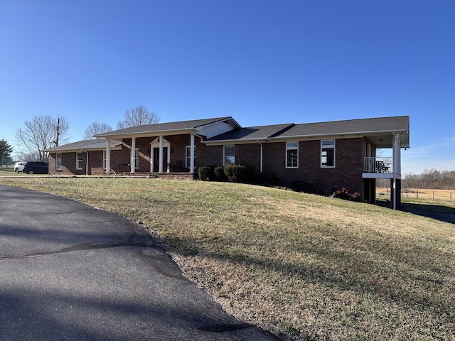 ranch-style house featuring a front yard and covered porch