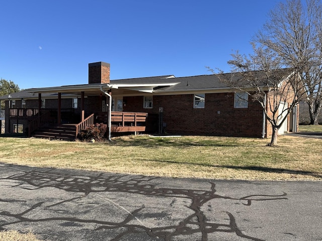 rear view of property featuring a lawn