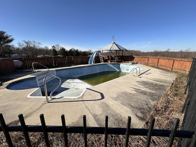 view of swimming pool featuring a gazebo, a water slide, and a diving board