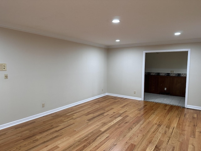 spare room with ornamental molding and light wood-type flooring