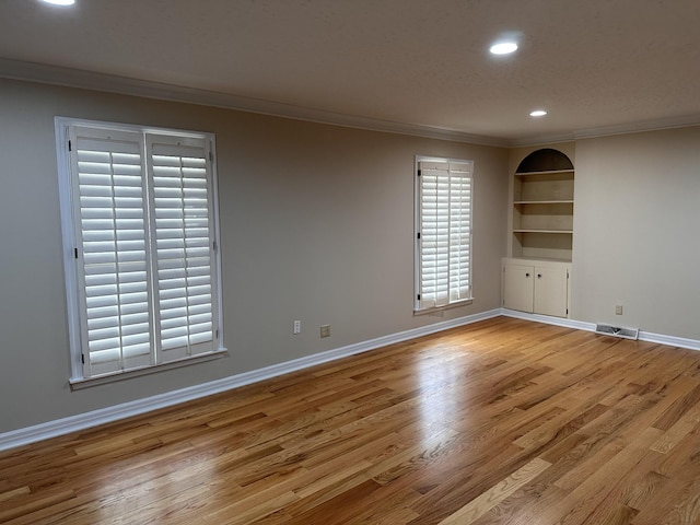 unfurnished room featuring crown molding and light hardwood / wood-style flooring