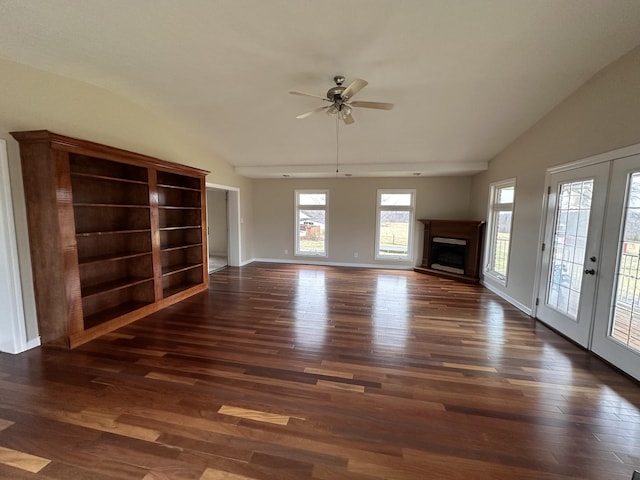 unfurnished living room with vaulted ceiling, dark hardwood / wood-style flooring, and french doors