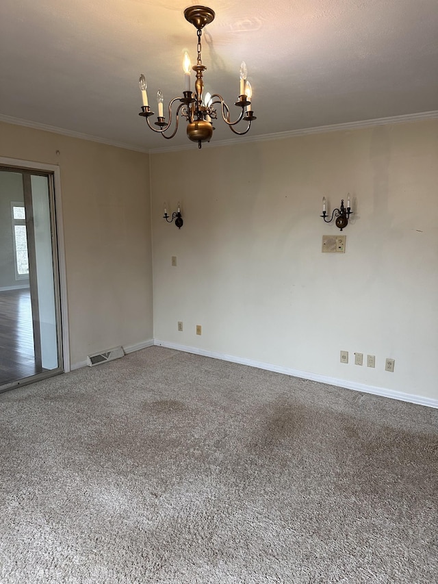 empty room featuring crown molding, a chandelier, and carpet