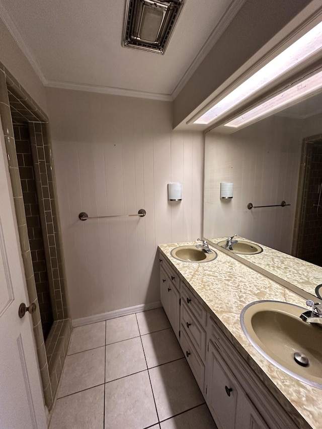 bathroom featuring ornamental molding, a tile shower, tile patterned floors, and vanity