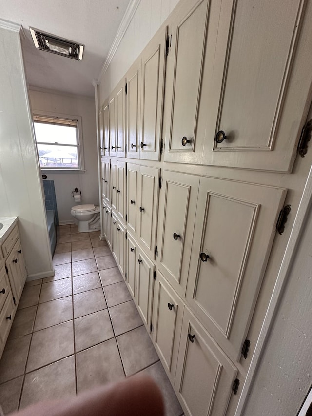 bathroom with crown molding, tile patterned floors, toilet, and vanity