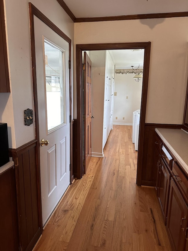 hallway featuring crown molding and light hardwood / wood-style flooring