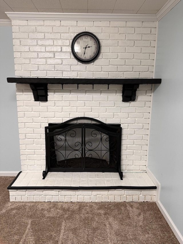 room details with a fireplace, ornamental molding, and carpet flooring