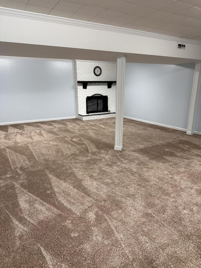 unfurnished living room with ornamental molding, a brick fireplace, and carpet floors