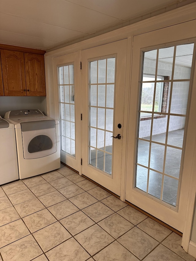 washroom featuring cabinets, light tile patterned floors, and washer and clothes dryer