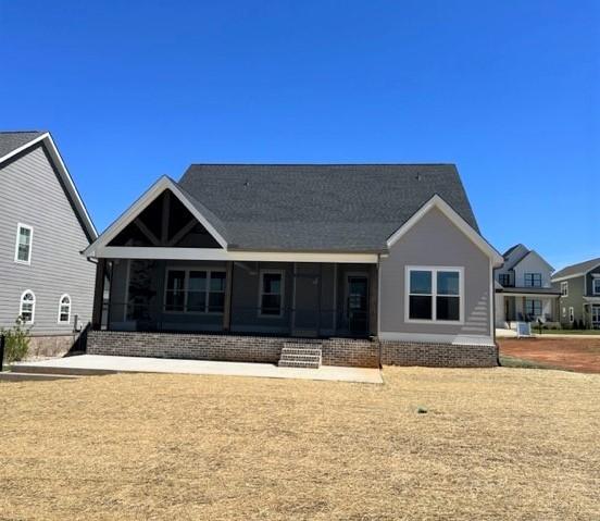 rear view of house with a sunroom and a lawn