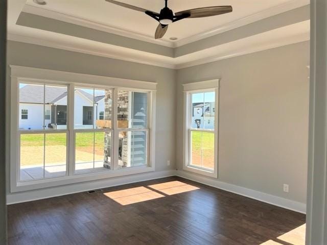 spare room with dark hardwood / wood-style floors, ornamental molding, and a raised ceiling