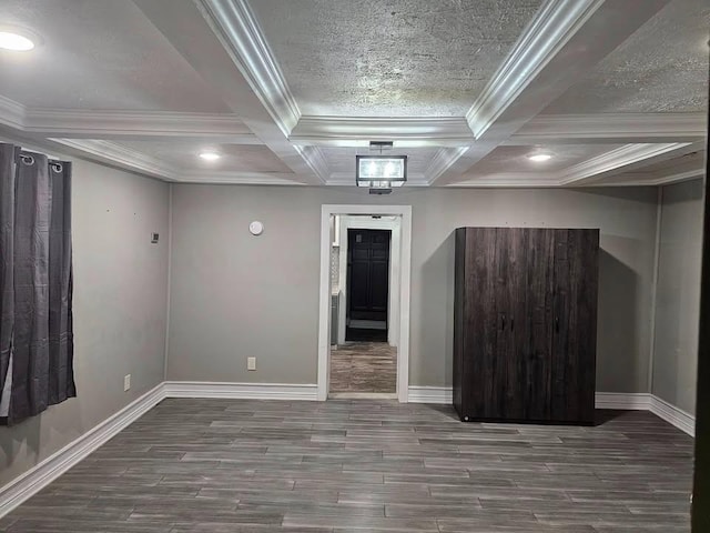 empty room featuring ornamental molding, coffered ceiling, hardwood / wood-style floors, and beam ceiling