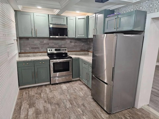 kitchen featuring ornamental molding, stainless steel appliances, coffered ceiling, and light wood-type flooring