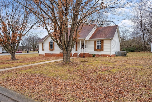 view of front of property with central AC and a front lawn