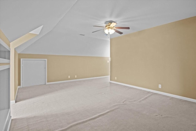 additional living space with ceiling fan, carpet flooring, and lofted ceiling with skylight