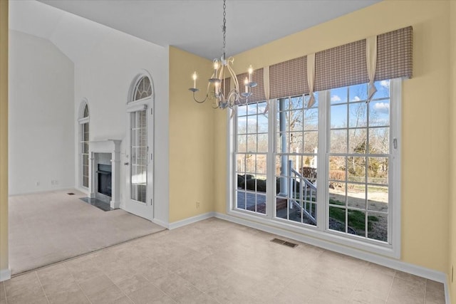 unfurnished dining area featuring a chandelier and carpet floors