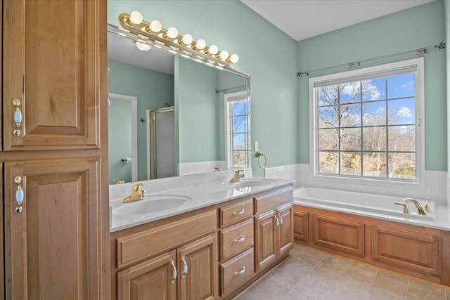 bathroom with tile patterned floors, plenty of natural light, plus walk in shower, and vanity