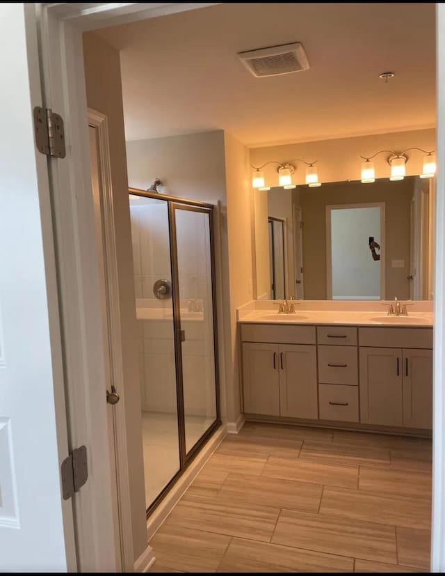 bathroom with vanity and a shower with shower door