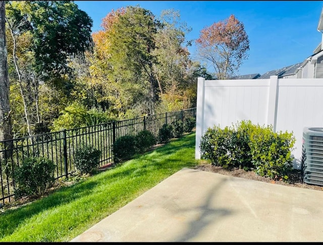 view of yard with central AC unit and a patio