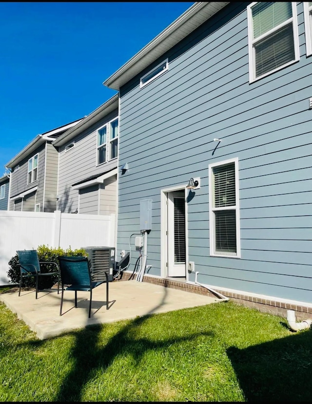 back of house with a patio and a yard