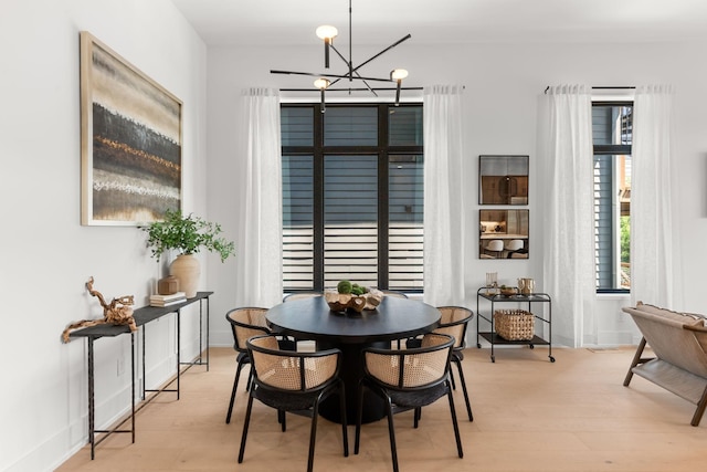 dining room with light hardwood / wood-style flooring and a notable chandelier