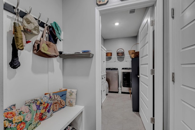 spacious closet with washer and clothes dryer and light tile patterned floors