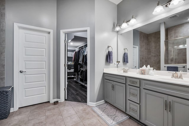 bathroom featuring vanity, tile patterned floors, and tiled shower