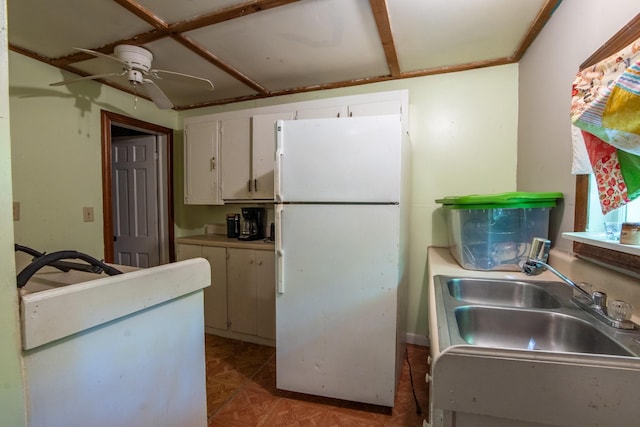 kitchen with sink, ceiling fan, white cabinetry, light parquet flooring, and white fridge