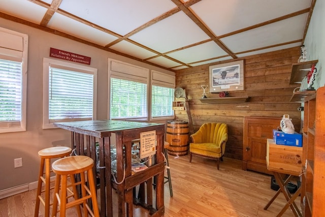 dining area with wood walls and light wood-type flooring