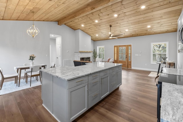 kitchen with decorative light fixtures, gray cabinets, light stone countertops, and wooden ceiling