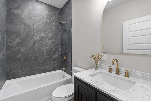 full bathroom with tiled shower / bath, vanity, and toilet