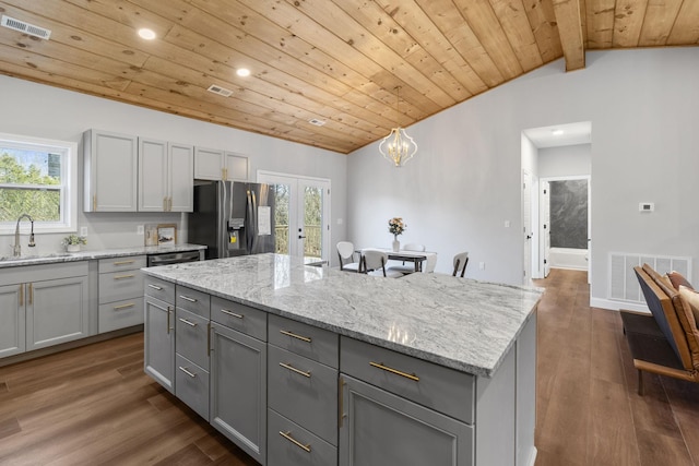 kitchen with a kitchen island, appliances with stainless steel finishes, sink, and gray cabinetry